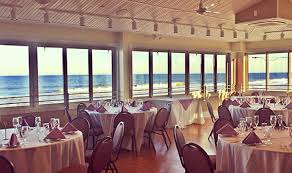 Elegant event space at Park Pavillion with ocean view, tables set for dining, and soft lighting, ideal for special occasions like weddings.