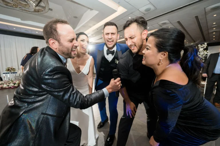 DJ Demby singing and holding microphone for a bride, groom, and another couple
