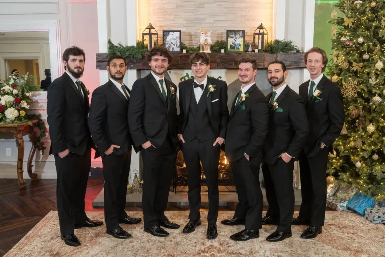 The groomsmen in front of the fireplace and Christmas tree at Jumping Brook