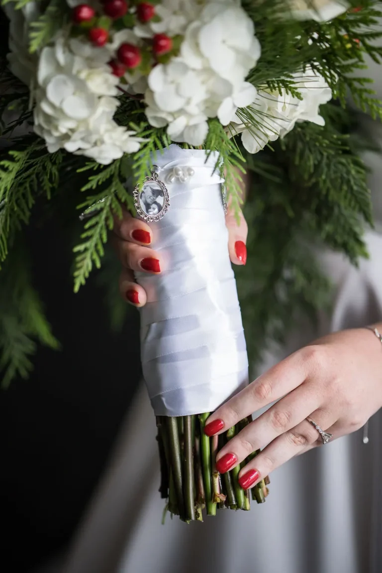 Close-up of Maura’s bouquet of white roses and evergreen