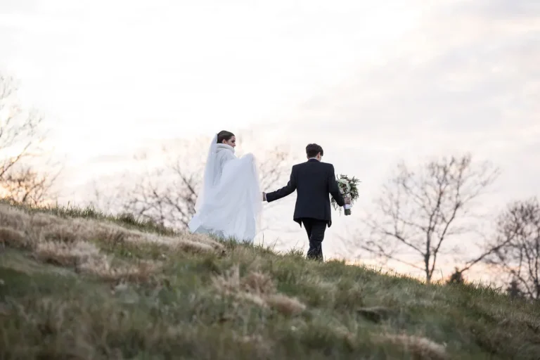 Maura and Christopher walking up a hill on the golf course at sunset