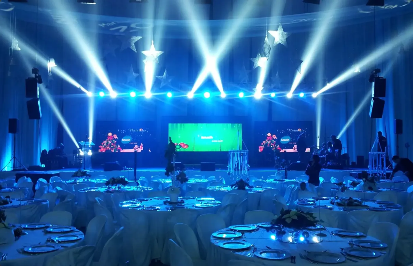 Corporate-style stage with TV screens and blue intelligent lighting by FNA Events